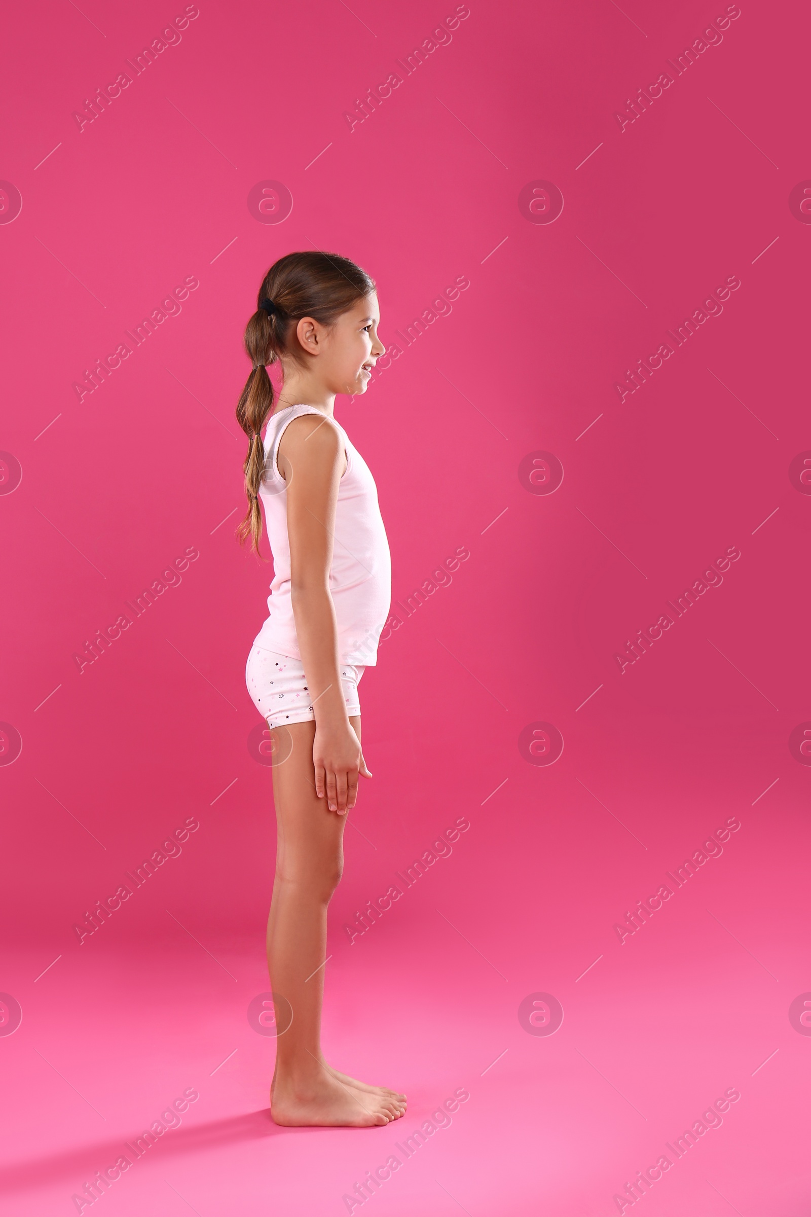 Photo of Cute little girl in underwear on pink background