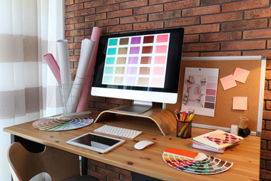 Photo of Modern computer and office supplies on wooden table. Designer's workplace