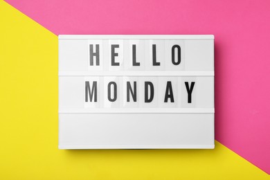 Light box with message Hello Monday on color background, top view