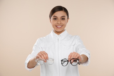 Photo of Female ophthalmologist with eyeglasses on light background