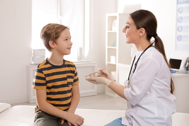 Doctor examining adorable child in hospital office