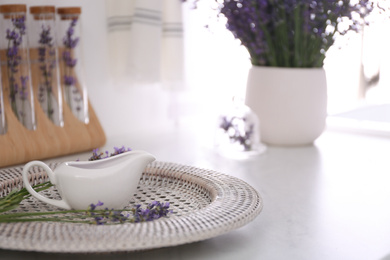 Photo of Beautiful lavender flowers and gravy boat on countertop indoors. Space for text