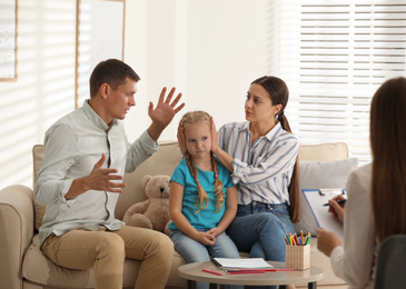 Family on appointment with child psychotherapist indoors