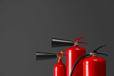 Fire extinguishers on grey background, closeup with space for text