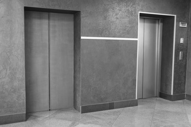 Photo of Closed stylish elevator doors in clean hall