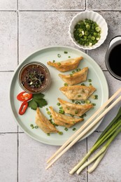 Delicious gyoza (asian dumplings) served on light tiled table, flat lay