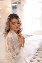 Happy bride with beautiful makeup and hairstyle at home. Wedding day