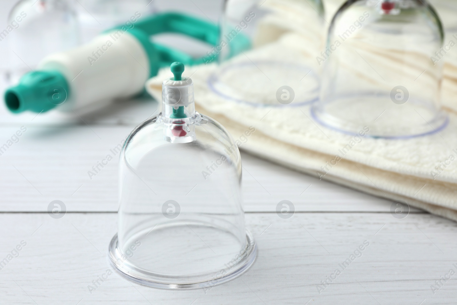 Photo of Cupping therapy. Plastic cups on white wooden table, closeup. Space for text