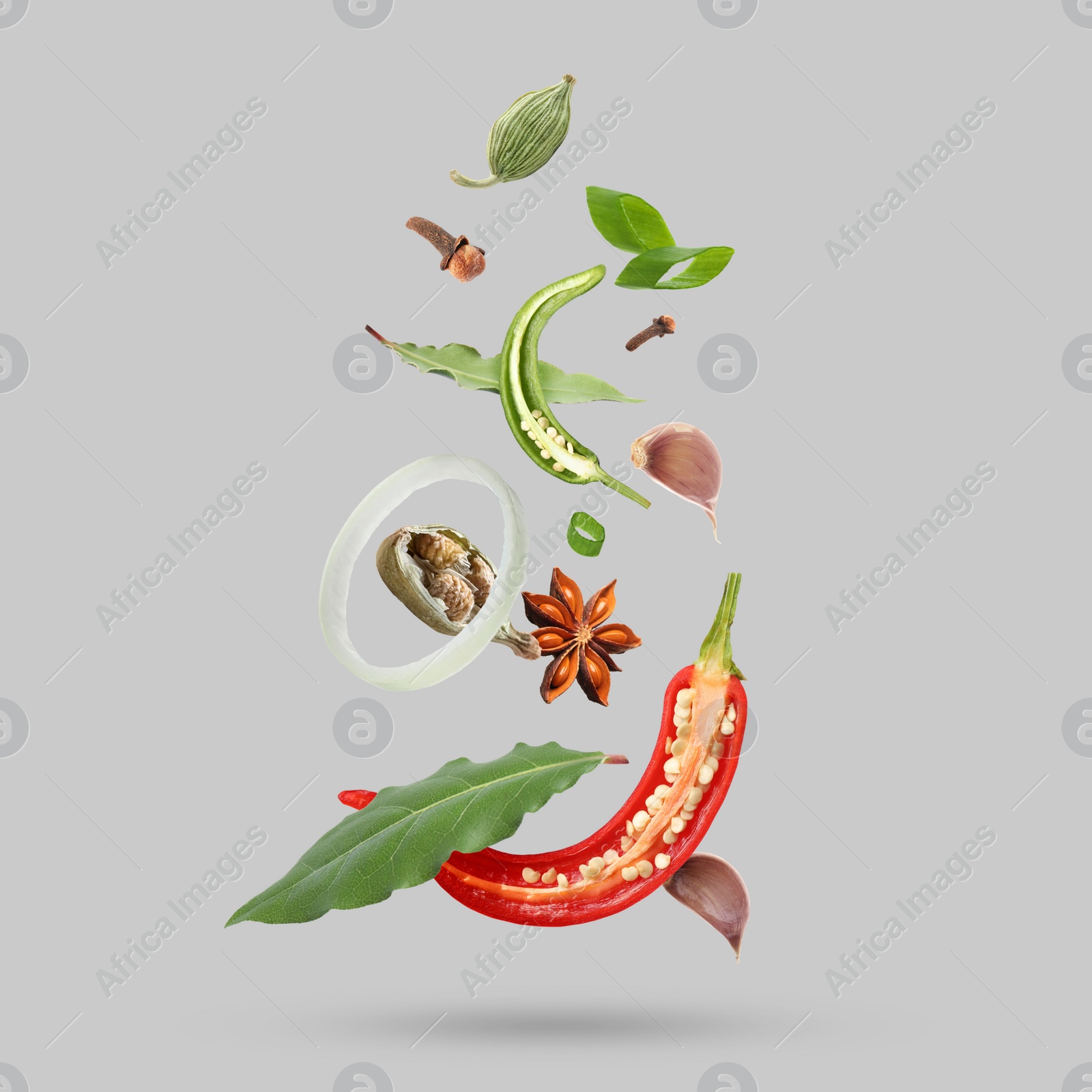 Image of Different spices falling on light grey background