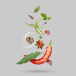 Image of Different spices falling on light grey background