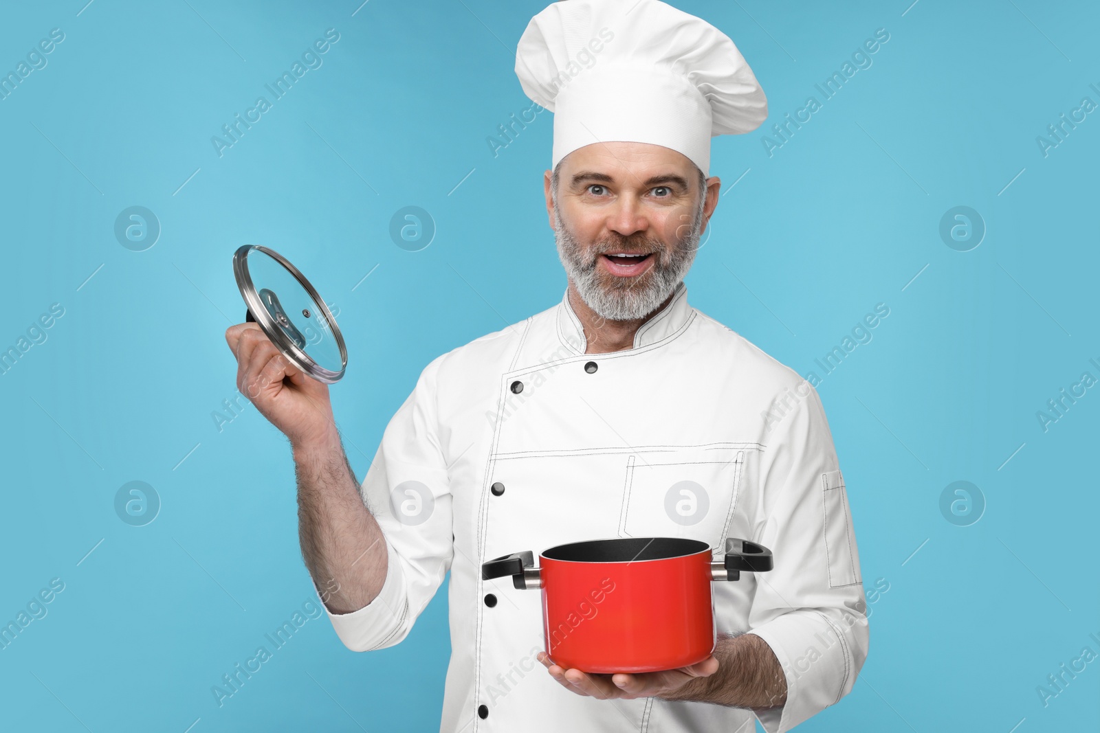 Photo of Surprised chef in uniform with cooking pot on light blue background