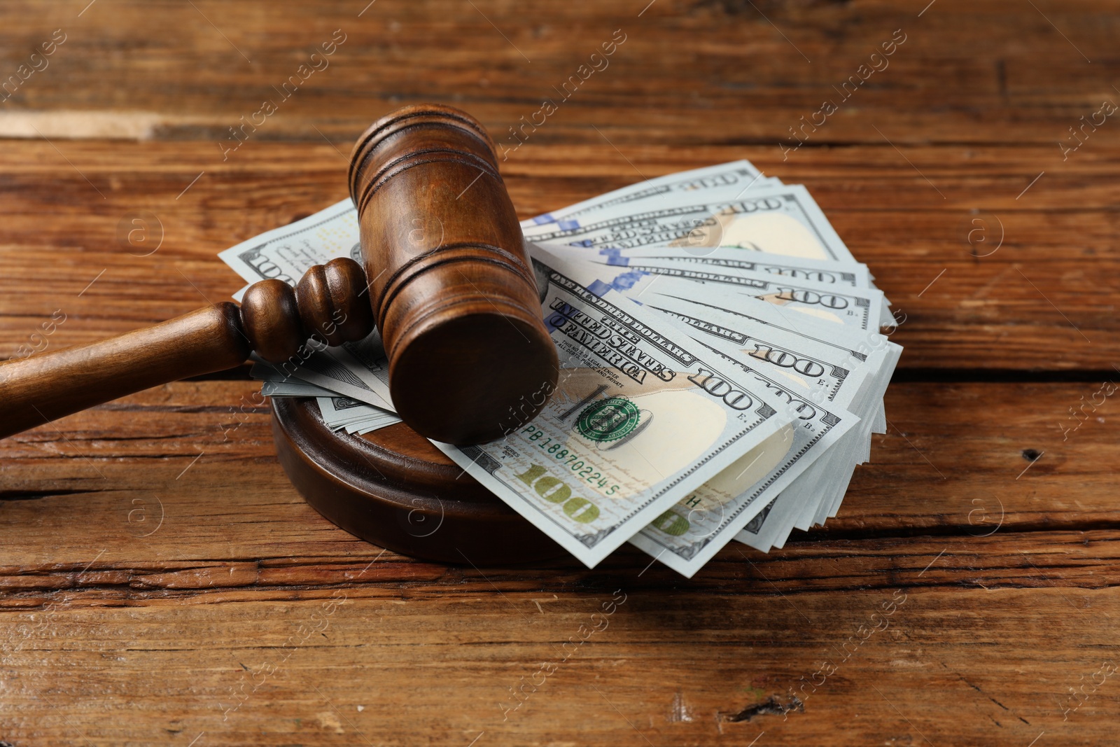 Photo of Judge's gavel and money on wooden table