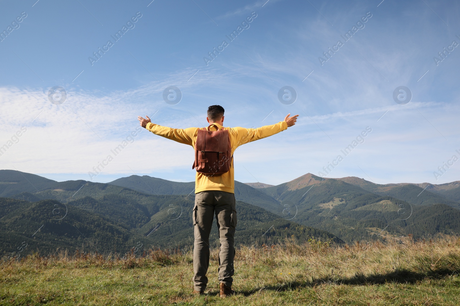 Photo of Man enjoying beautiful mountain landscape, back view