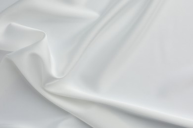 Texture of crumpled white silk fabric as background, top view