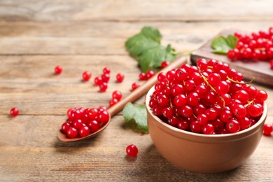 Delicious red currants on wooden table. Space for text