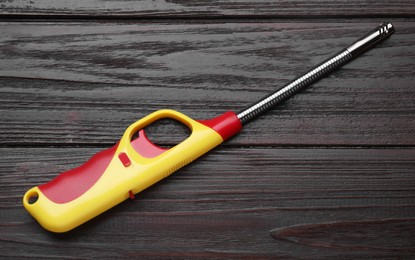 One gas lighter on wooden table, top view