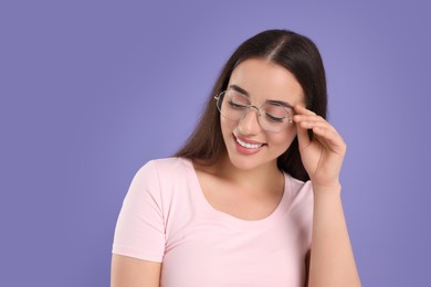 Photo of Beautiful woman wearing glasses on violet background. Space for text