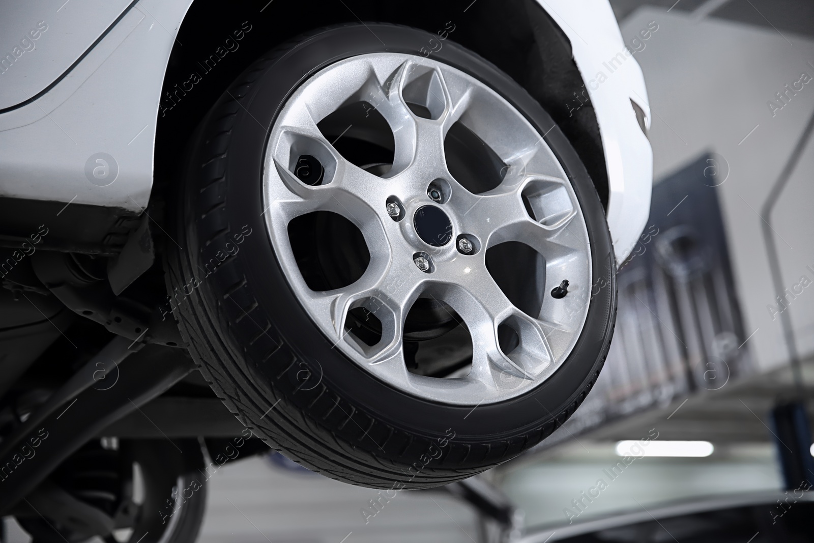 Photo of Car on lift at tire service, closeup