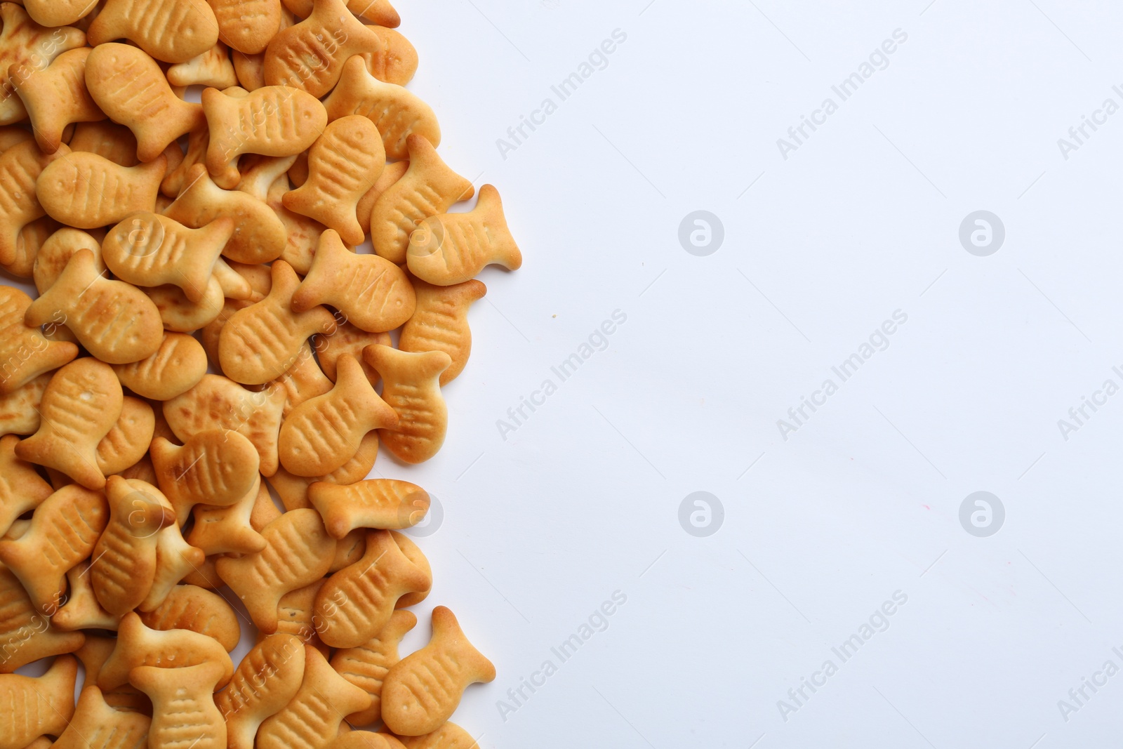 Photo of Delicious goldfish crackers on white background, top view