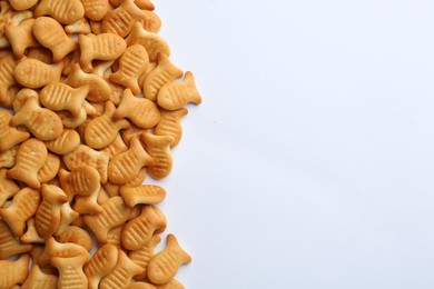 Photo of Delicious goldfish crackers on white background, top view