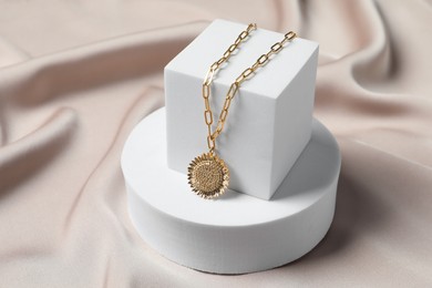 Photo of Stylish presentation of elegant necklace on beige cloth