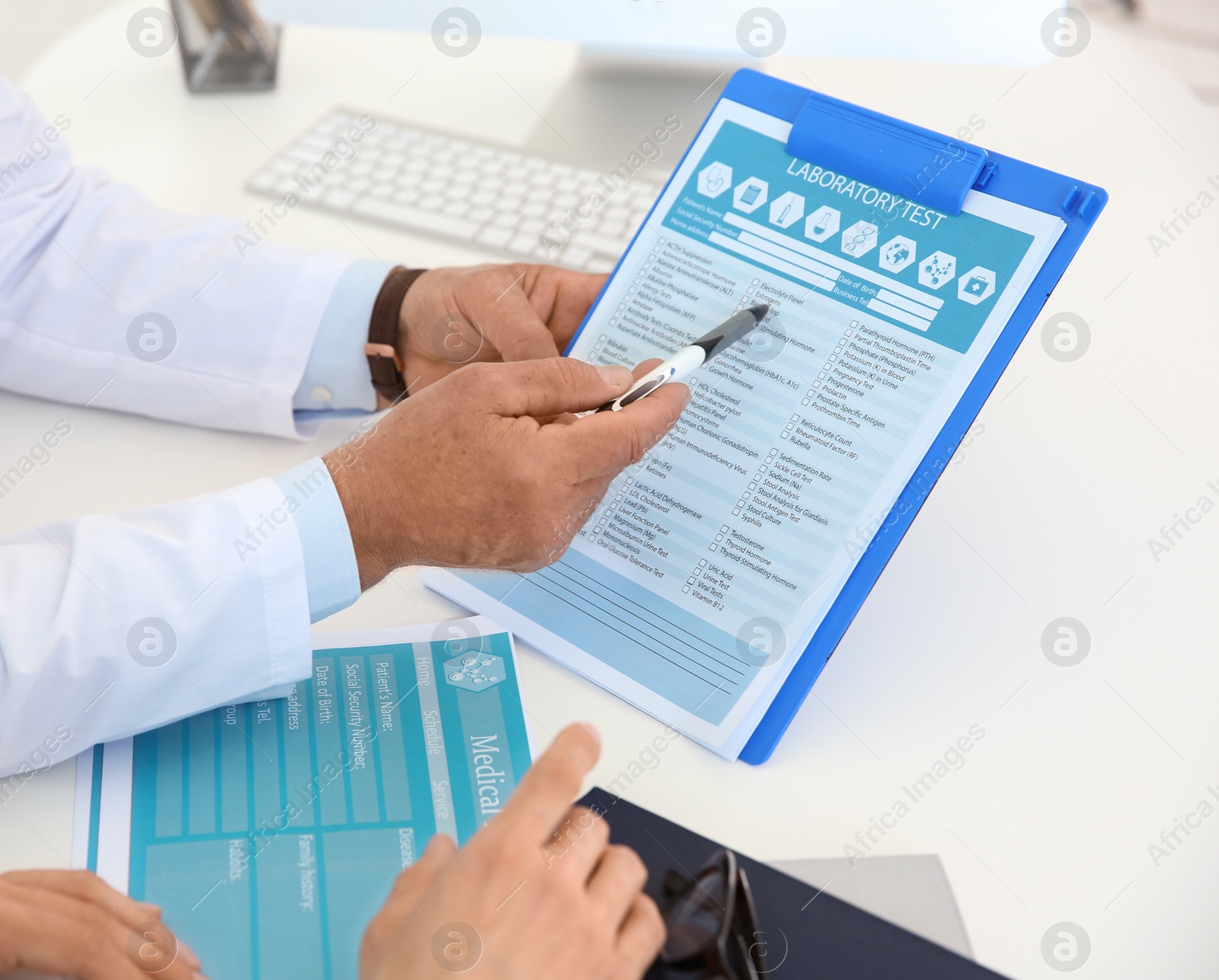 Photo of Urologist showing laboratory test form to patient in hospital