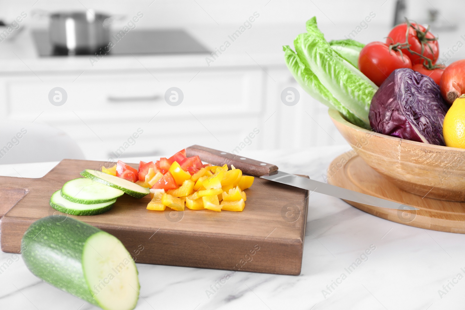 Photo of Different raw vegetables on white marble table in kitchen