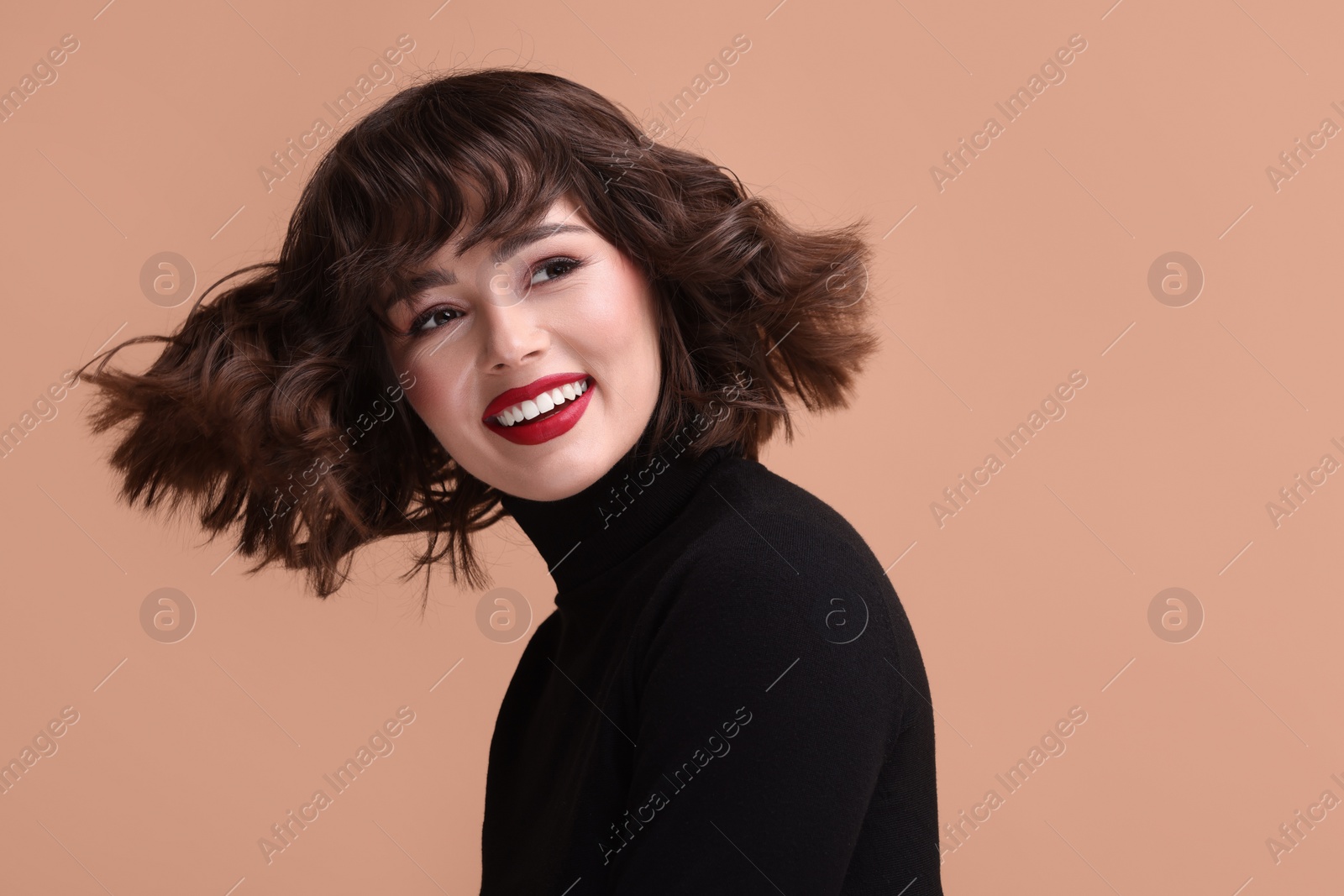 Photo of Portrait of beautiful young woman with wavy hairstyle on beige background. Space for text