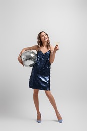 Beautiful woman with disco ball on white background