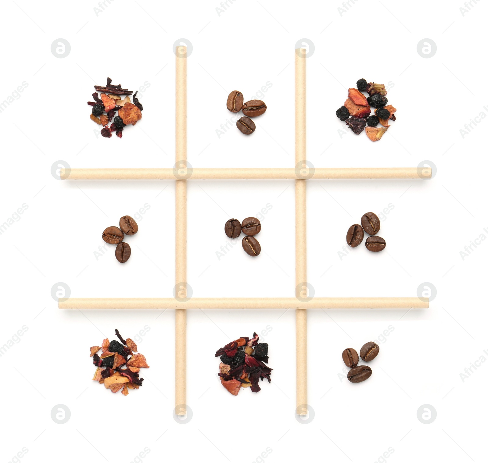 Photo of Tic tac toe game made with coffee beans and dry tea leaves isolated on white, top view