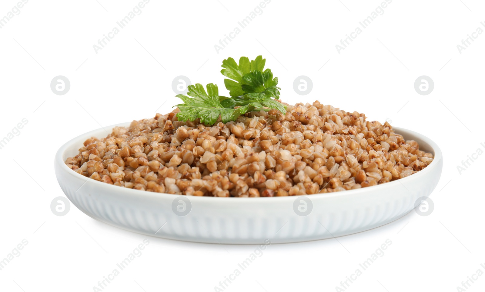 Photo of Plate of buckwheat porridge with parsley isolated on white