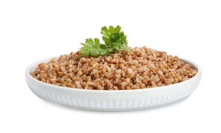 Photo of Plate of buckwheat porridge with parsley isolated on white