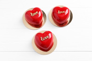 Photo of St. Valentine's Day. Delicious heart shaped cakes on white wooden table, above view