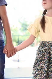 Photo of Children holding hands on blurred background. Unity concept