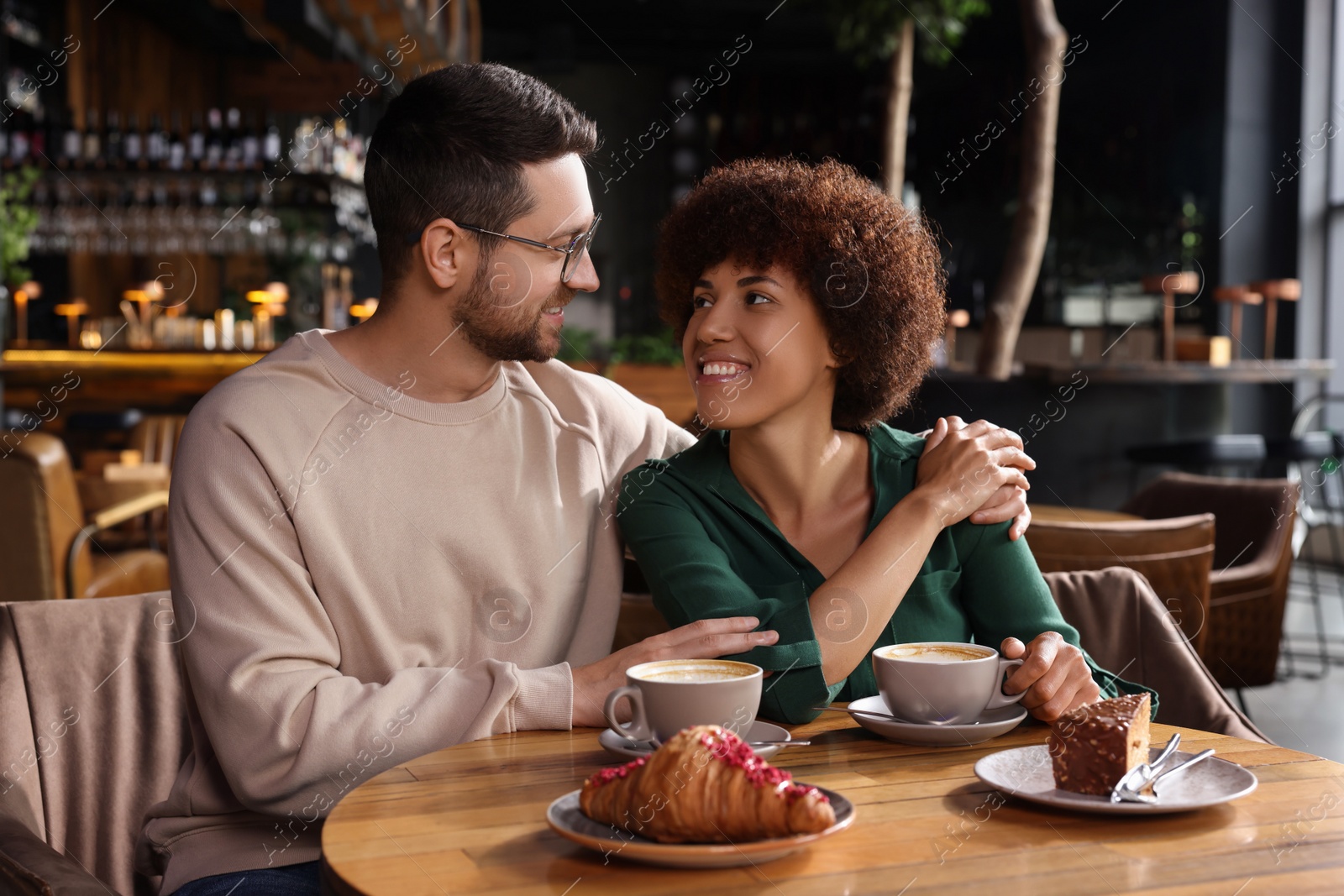 Photo of International dating. Lovely couple spending time together in cafe