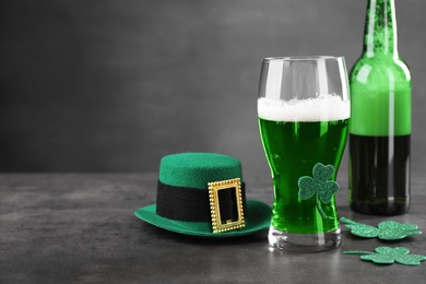 St. Patrick's day celebration. Green beer, leprechaun hat and decorative clover leaves on grey table. Space for text