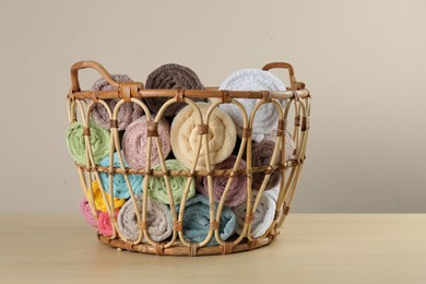 Photo of Wicker basket with clean soft towels on wooden table