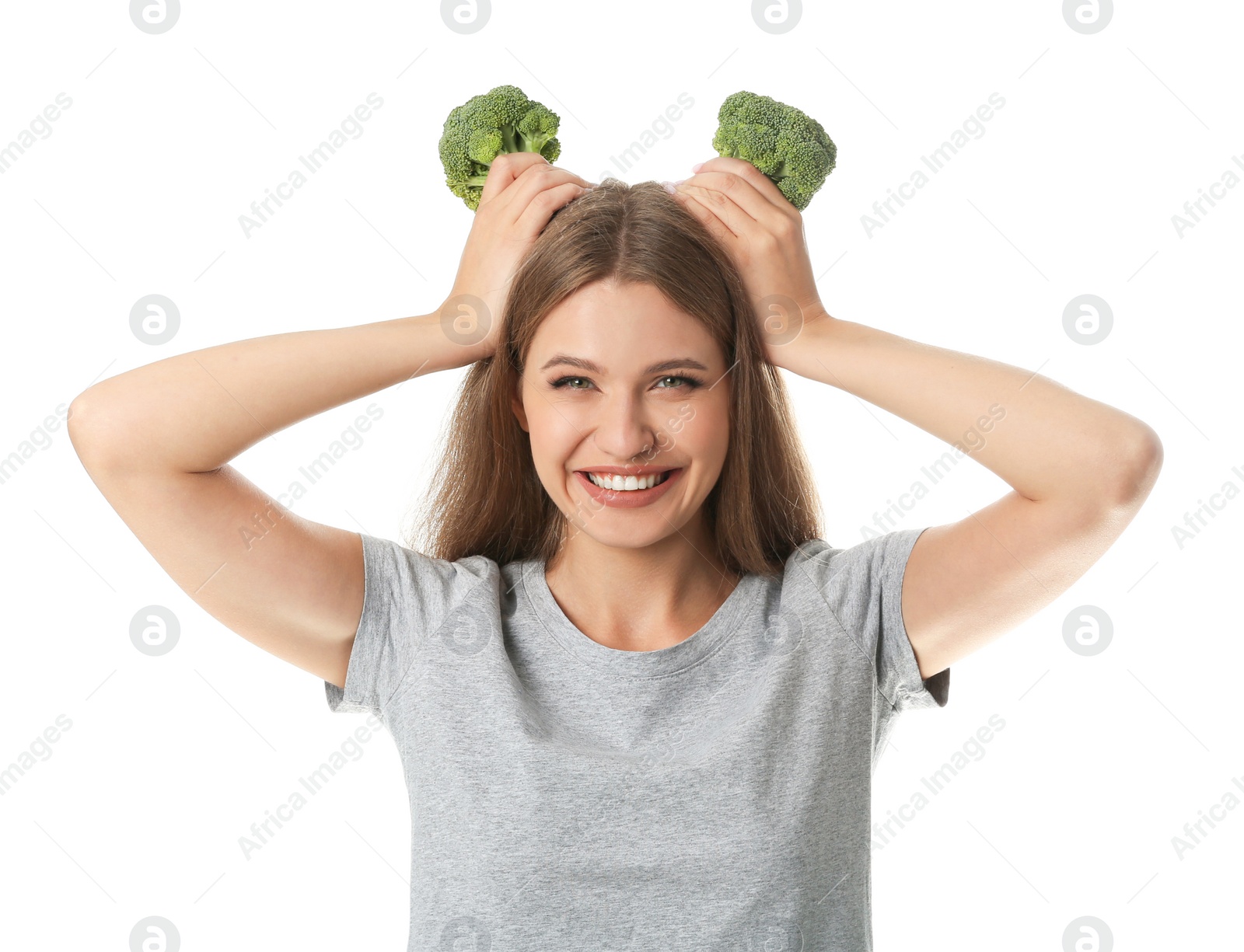 Photo of Portrait of funny woman holding broccoli as horns on white background