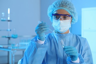 Photo of Scientist dripping sample into test tube in laboratory. Medical research