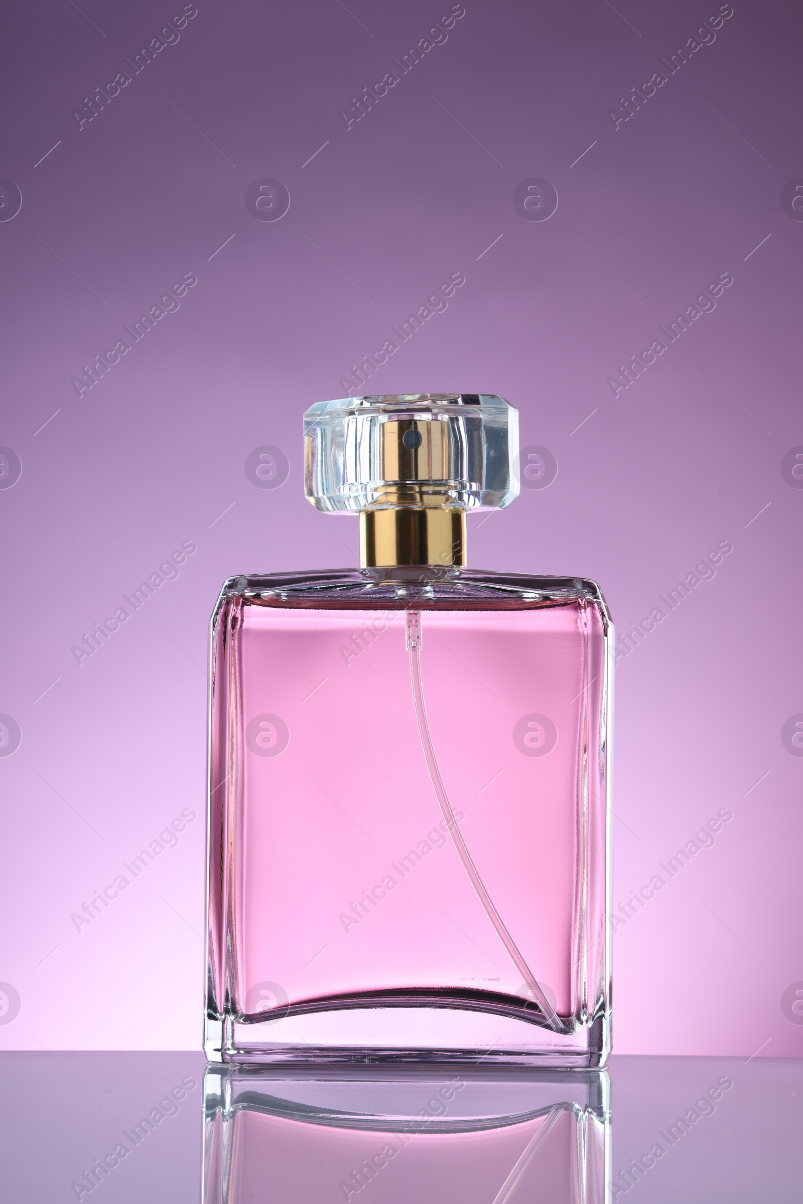 Photo of Luxury women's perfume in bottle on violet background