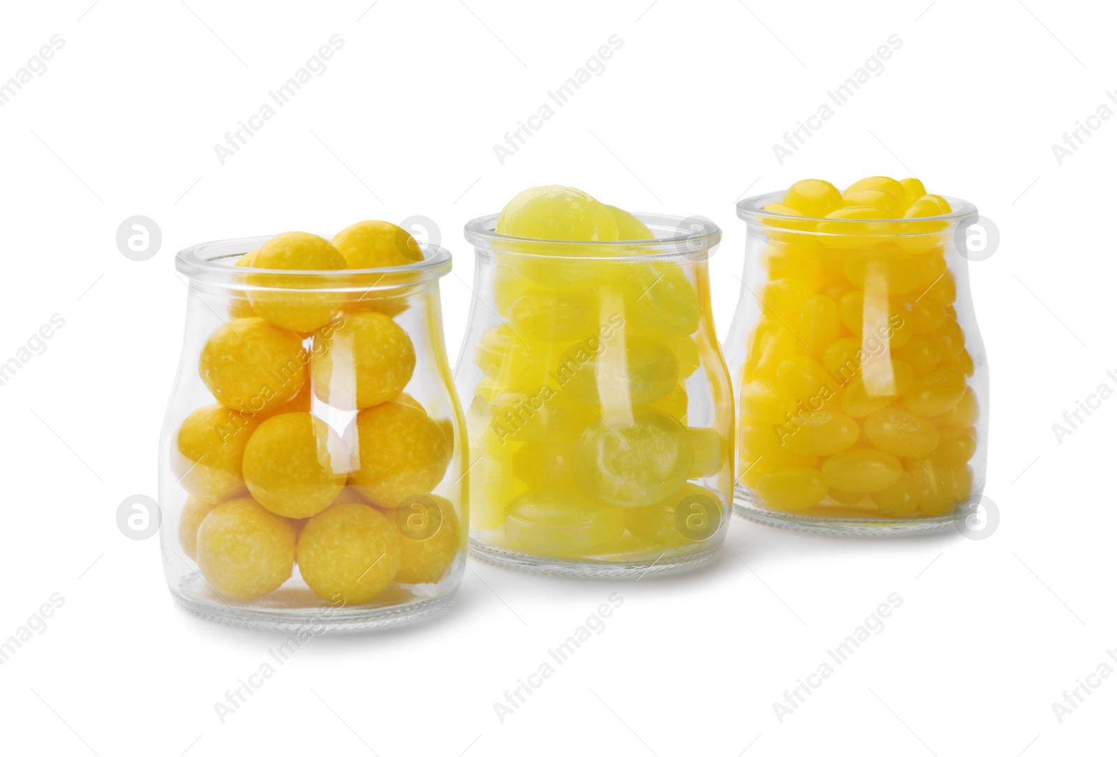 Photo of Different tasty lemon drops in jars isolated on white