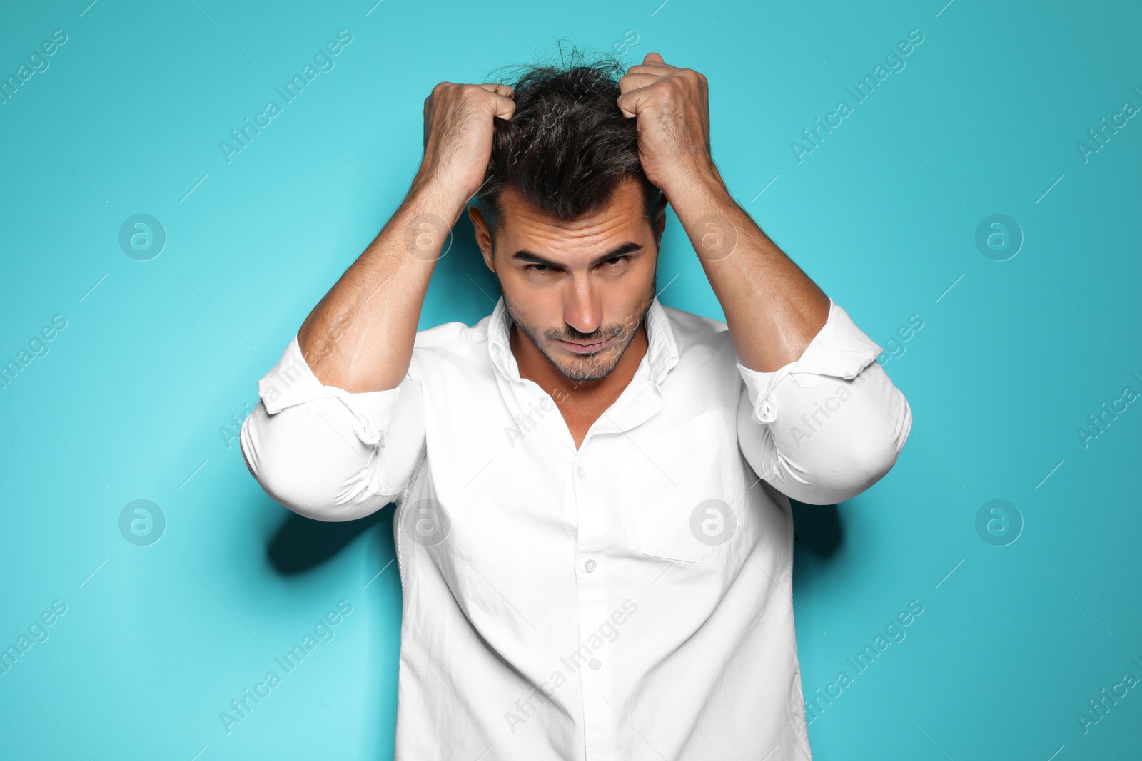 Photo of Young man with trendy hairstyle posing on color background