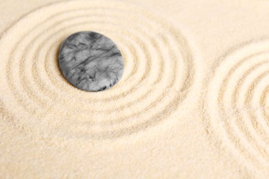 Photo of Zen garden stones on beige sand with pattern