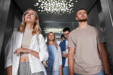 Group of young people in modern elevator
