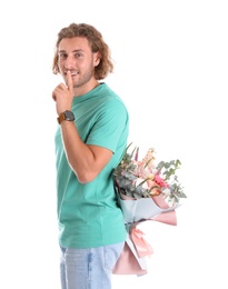 Photo of Young handsome man hiding beautiful flower bouquet behind his back on white background