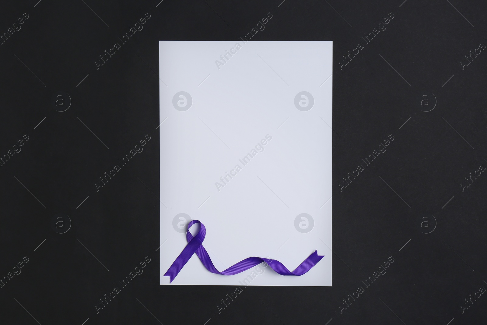 Photo of Purple awareness ribbon and blank card on black background, top view with space for text