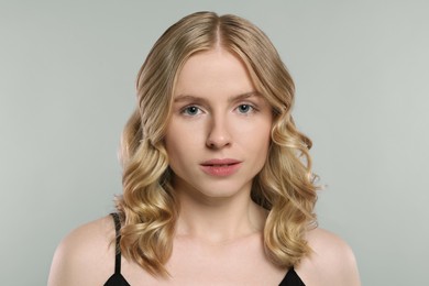 Photo of Portrait of beautiful woman with blonde hair on light grey background