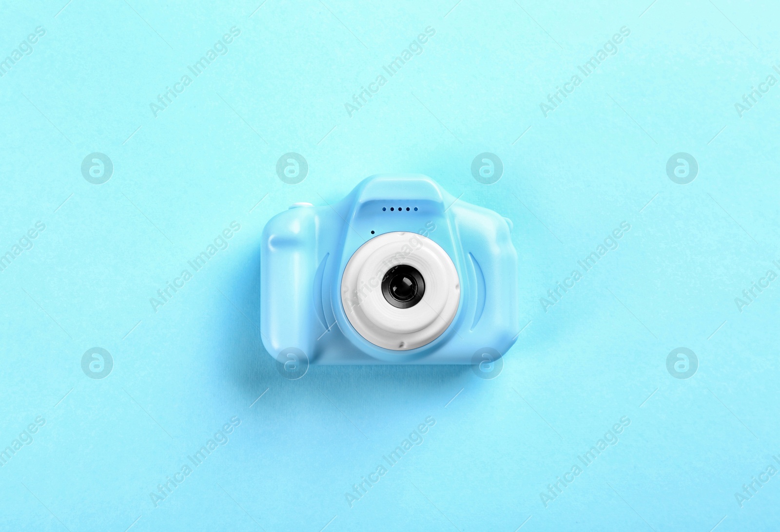 Photo of Toy camera on light blue background, top view