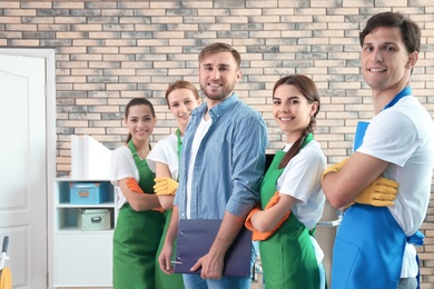 Team of professional janitors in uniform indoors