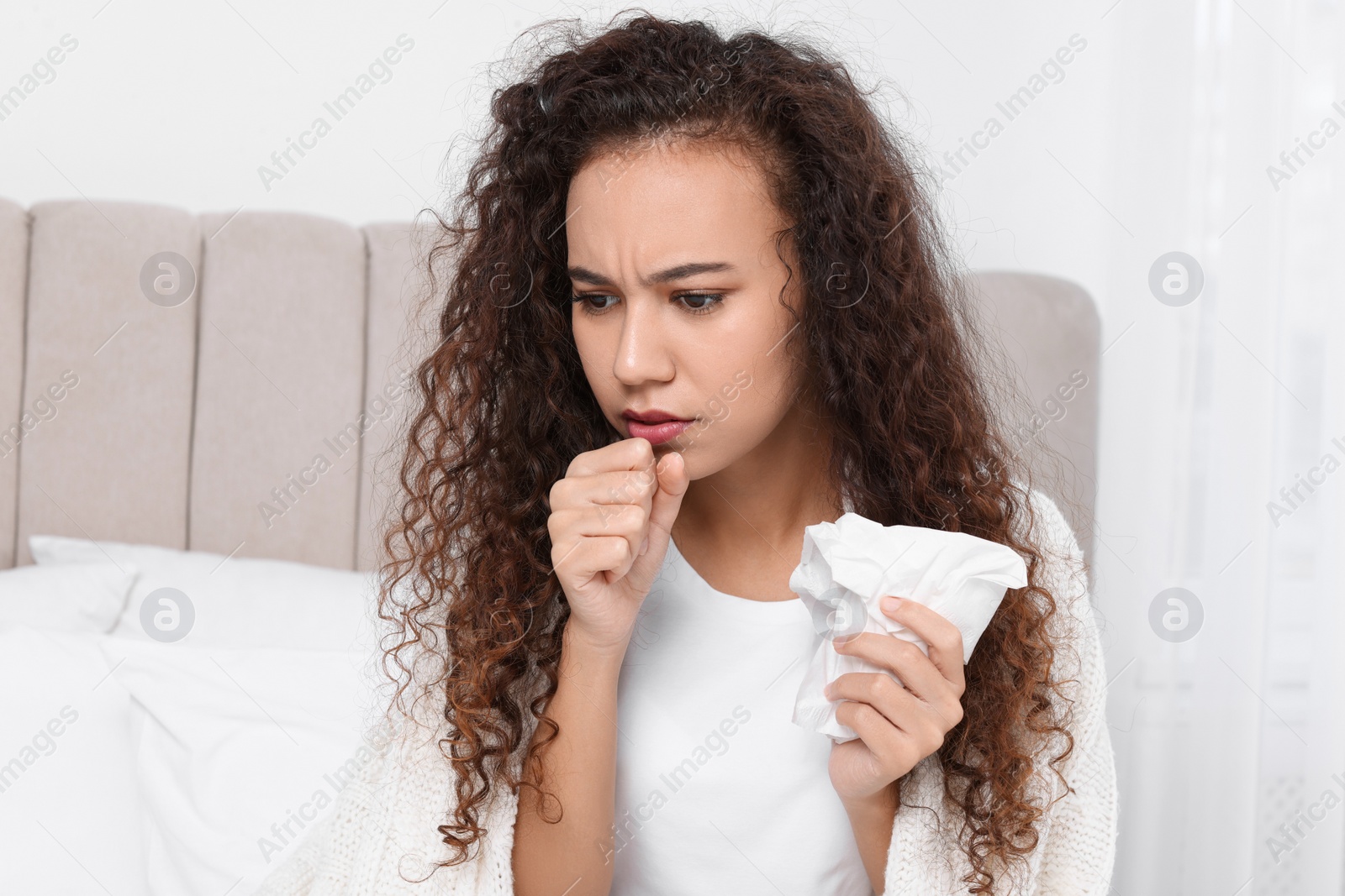 Photo of Sick African American woman with tissue in bed at home